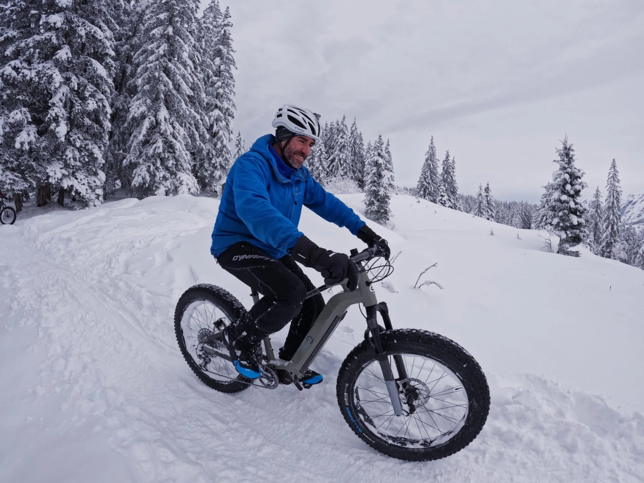 Randonnée en VTT fatbike électrique sur neige, entre les sapins